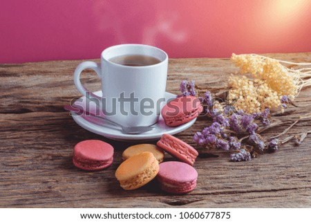 Different types color of macaroons Cup of hot tea on Old grunge wooden background Decorated with dried flowers Vintage style