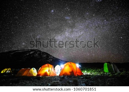 Camping in tents on mount Kilimanjaro at night with stars in sky to see the glaciers at the summit, Africa