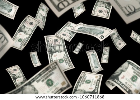 Flying ten American dollar banknotes, isolated on black background