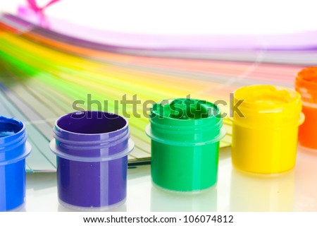 colorful jars with gouache on a palette background close-up