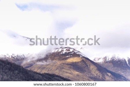 View of snow-capped mountains and lakes under a sombre cloudy sky