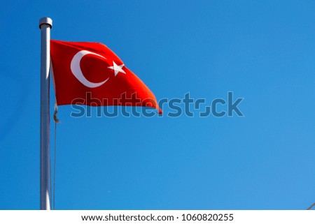 Bright Turkish flag waving in the wind on blue sky background