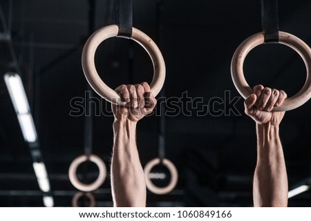 Young Male Athlete With Gymnastic Rings In The Gym. focus on rings