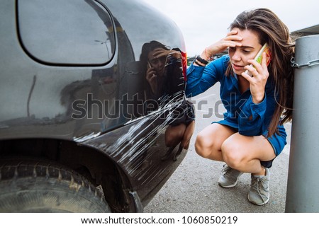 woman stand near scratched auto. call for help. car insurance Royalty-Free Stock Photo #1060850219