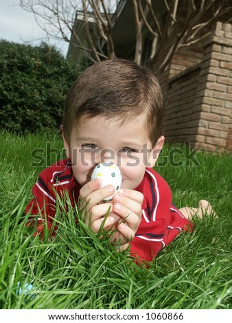 A young boy holding an Easter egg.