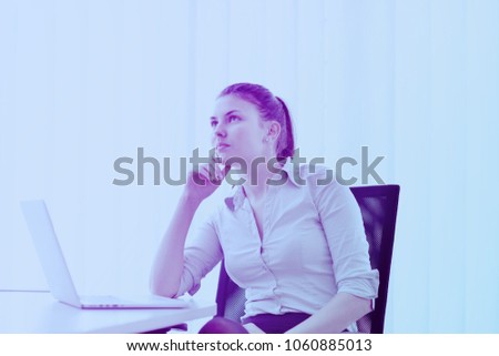 portrait of Young pretty business woman work on  notebook computer  in the bright modern office indoors