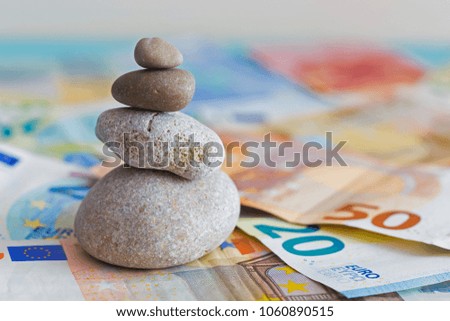 Pyramid of stones and euro banknotes