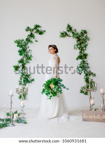 Beautiful bride posing in wedding dress in a white photo Studio