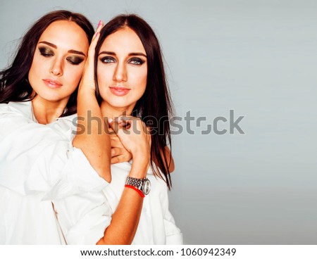 two sisters twins girl posing, making photo selfie, dressed same
