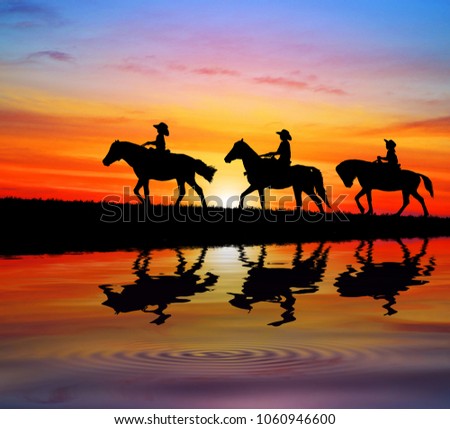 silhouette cowboy and horse and water reflection 