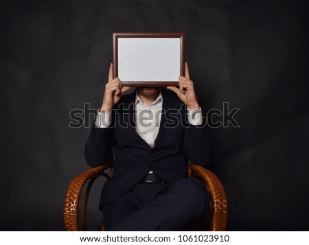 In the hands of a businessman a frame with the inscription: