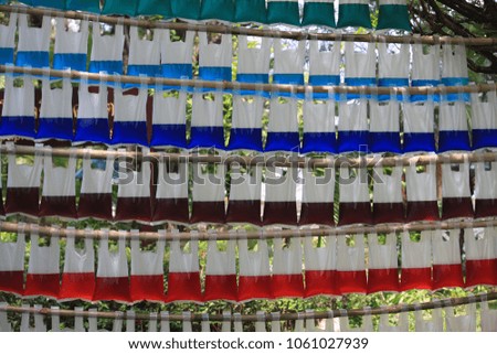 A lot of color water (red, yellow, blue and brown) in the bags hanged together.