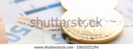 The coin of crypto currency bitcoin against background euro banknote subject gold exchange pyramid for money in connection with the growth or fall exchange rate closeup.