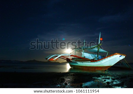 The moon rises in a starry sky over the sea and offers a beautiful show, Philippines, Palawan Island