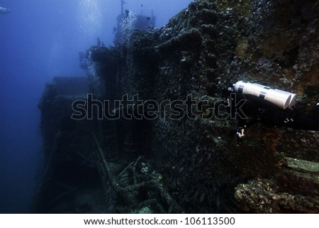 A technical female diver swimming alongside the USCG Duane. A sunken shipwreck in the John Pennekamp State Park in Key Largo, Florida. Royalty-Free Stock Photo #106113500
