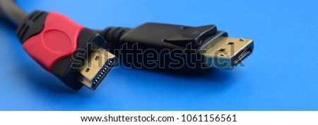 Audio video HDMI computer cable plug and 20-pin male DisplayPort gold plated connector for a flawless connection on a blue background Royalty-Free Stock Photo #1061156561