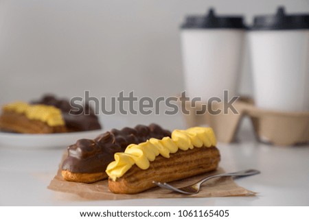 Traditional French eclairs with coffee. Good Breakfast. Closeup. On white background