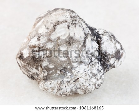 macro shooting of natural mineral rock specimen - native cacholong stone on white marble background from Kazakhstan