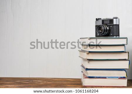 old camera over stack of books