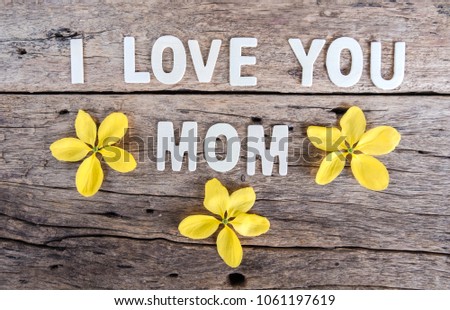 Word "I love you mom" with spring flower on wooden background.
Mother's day celebration and mother's day concept.