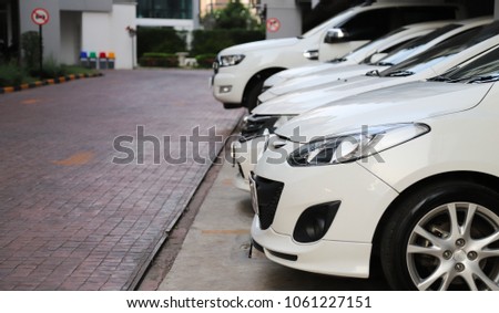 Closeup of front side of white cars parking in parking lot. The mean of people for transportation in the city.