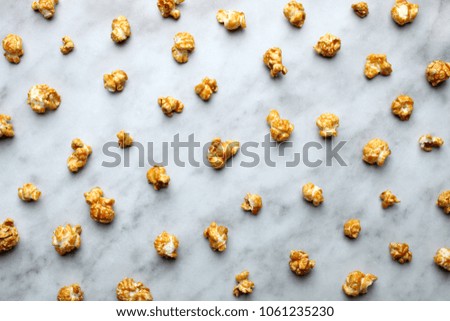 Grains of caramel popcorn on a marble background. Top view. 