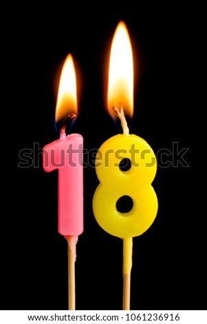 Burning candles in the form of 18 eighteen figures (numbers, dates) for cake isolated on black background. The concept of celebrating a birthday, anniversary, important date, holiday, table setting