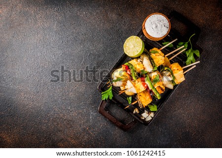 Vegan diet food, Grilled cheese and vegetables kebab, indian style Paneer Tikka, with white sauce and lime, on dark concrete background, copy space top view Royalty-Free Stock Photo #1061242415