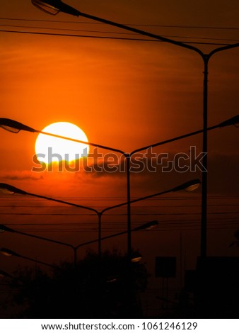 The Power Lamp Poles behind The Sun and Clouds  in The Morning