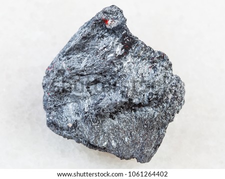 macro shooting of natural mineral rock specimen - raw antimony ore (Stibnite) stone on white marble background from Ukraine