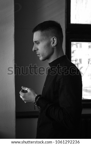 Low key strong portrait young attractive man with piercing. black and white