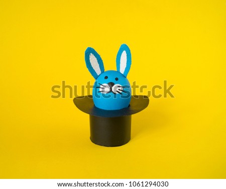 The concept of Easter with cute and cheerful handmade eggs, a rabbit.Circus Yellow background. Funny egg. Painted Easter eggs in different moods and facial expression 