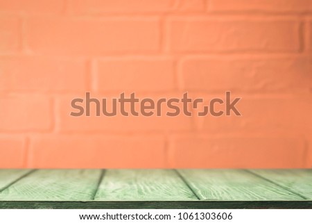Orange-green background. Worktop and brick wall.