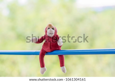 Red monkey doll on plastic pipe