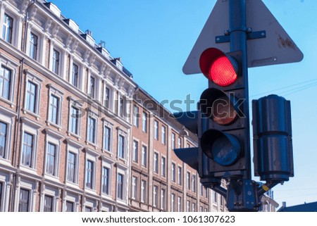A traffic stop light is on red  with typical Danish buildings in the background in Copenhagen