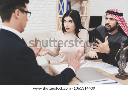 Lawyer in suit in office with arab husband and wife. Lawyer is trying to calm couple down.
