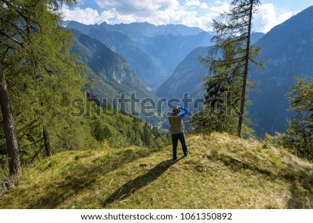 A Hiker taking picture of Mountain View and Valley from Vrsic pass, Julian Alps, Slovenia