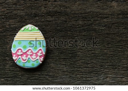 gingerbread cookie in the form of color eggs on dark wooden background. Happy Easter card. Bright biscuits. Treats for children. copy space