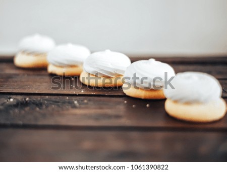 cookies with a zephyr lie on a wooden background in a row