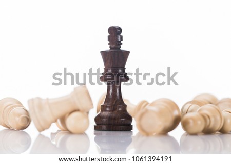 black chess king with fallen white pawns on white, business concept
