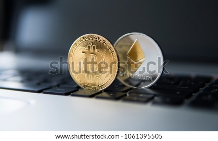 Golden bitcoin and Ethereum coins on a laptop. Crypto currency on a computer black keyboard. Digital currency. Virtual money. Metal coins of bitcoin. Bussiness, commercial, Exchange. Digital Money.