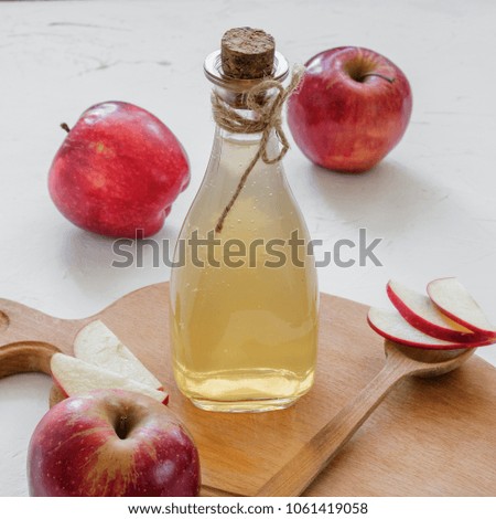 Apple vinegar. Bottle of apple organic vinegar on white background with whole raw red apples. Healthy organic food.