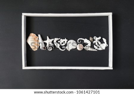 White wooden frame with few marine items over black background.