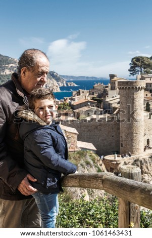 Grandfather and grandson on vacation in a medieval town. Tossa de Mar. Spain.