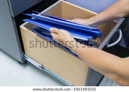 Man hands Search files document in a file cabinet . retention of contracts - concept