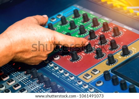 Music Control Tuning : Close up the audio engineer's hands, adjust the sound on the control panel.

