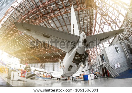 Passenger aircraft on service in an aviation hangar rear view of the tail, on the auxiliary power unit Royalty-Free Stock Photo #1061506391