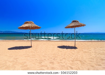 Summer umbrellas with blue sea and blue sky as a background