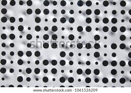 Black and white pattern with round holes.
