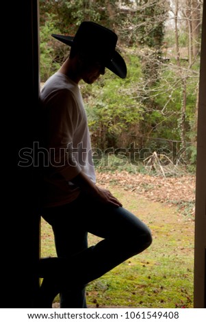 cowboy standing in a doorway Royalty-Free Stock Photo #1061549408
